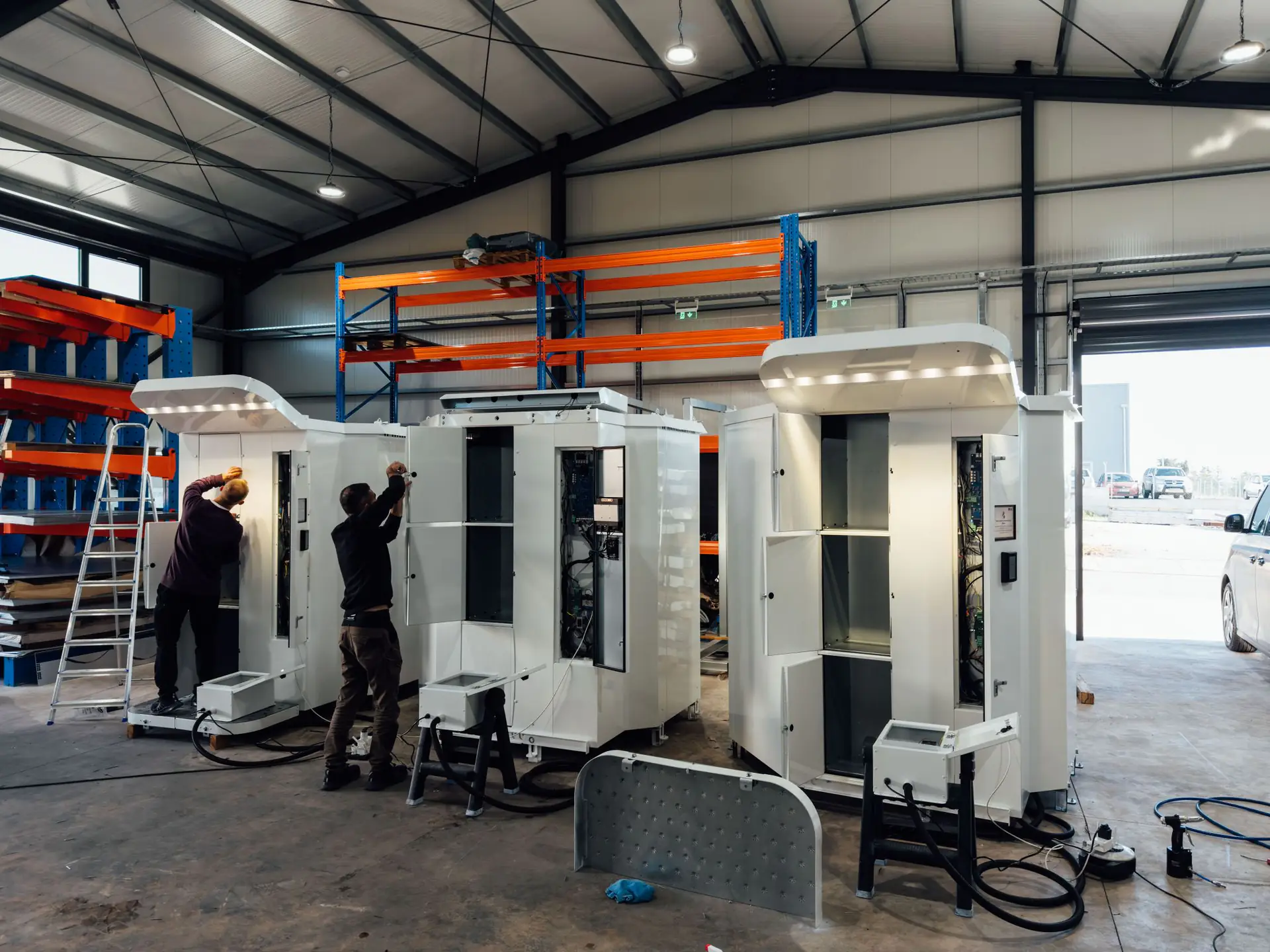 Técnicos montam máquinas GasAutomat na fábrica da VendingRobotics em Pafos. As coberturas LED estão acesas.